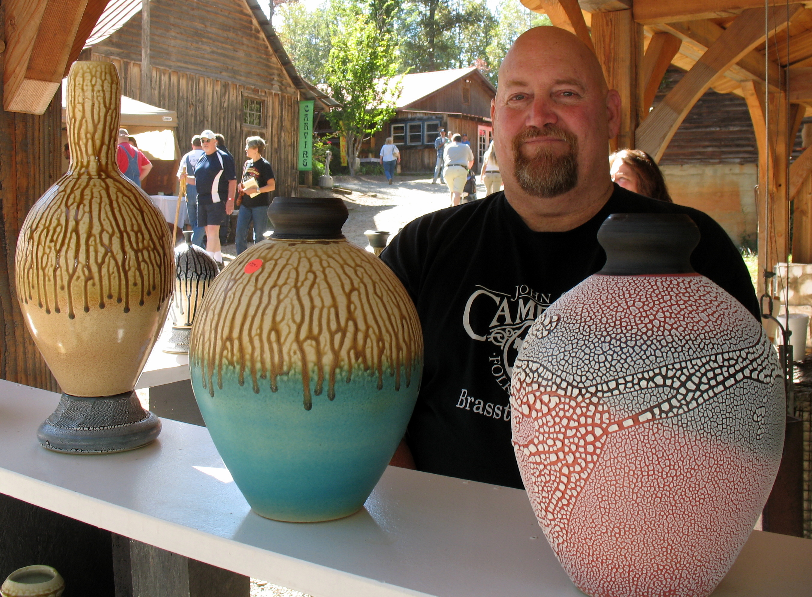 Mike Lalone stands behind his pottery