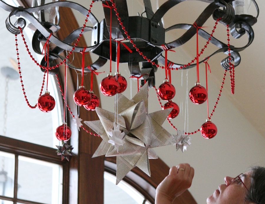 A large Moravian star made from old Folk School catalog paper hangs from each of the iron chandeliers in the Dining Hall.