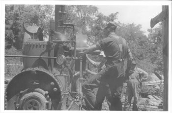 Oscar Kentrell (the first Folk School Blacksmith) operating the steam driven threshing and bailing machine