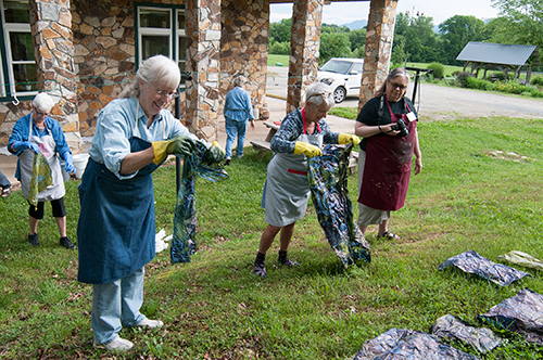 Students place their pieces from the dye pot on the grass to let the oxidation process develop.