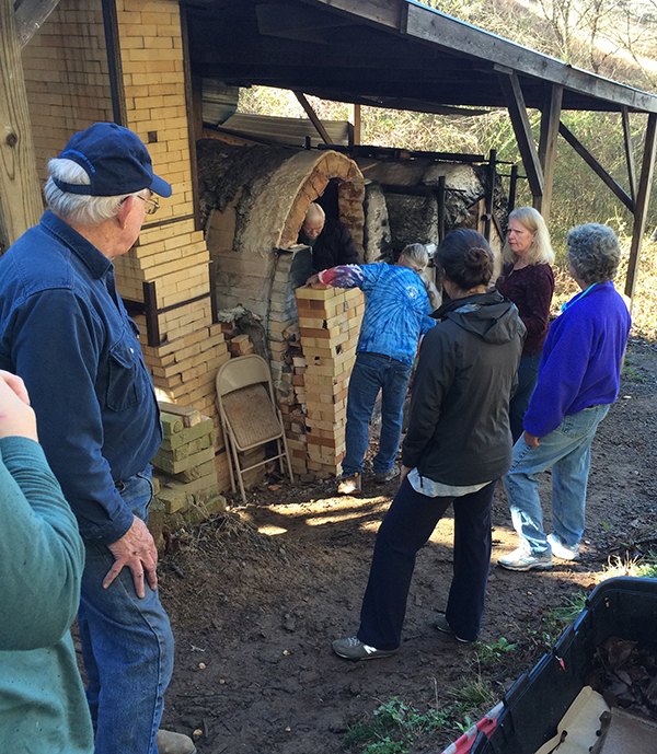 The community helps to unload the kiln, fire brigade-style.