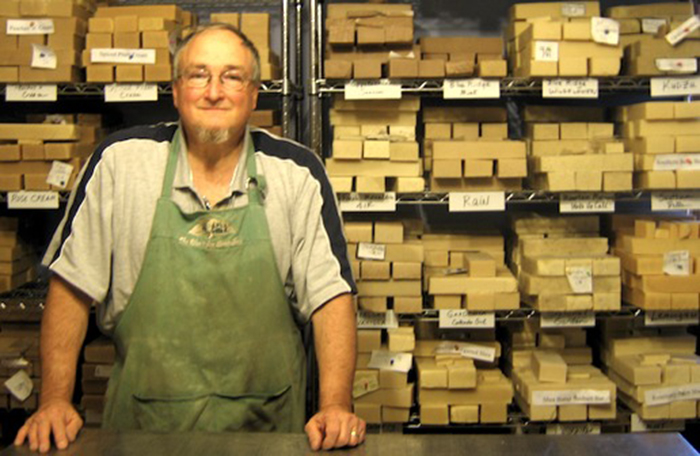 Tim Tyndall front of the soap drying racks at the Soap Shed