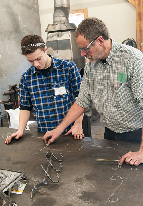 Aaron Niederman plans his Blacksmithing project with instructor Ron Nichols.