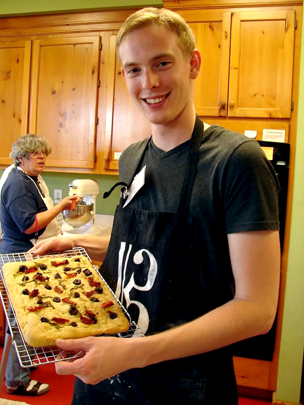 Nicholas holds the focaccia fresh out of the oven.