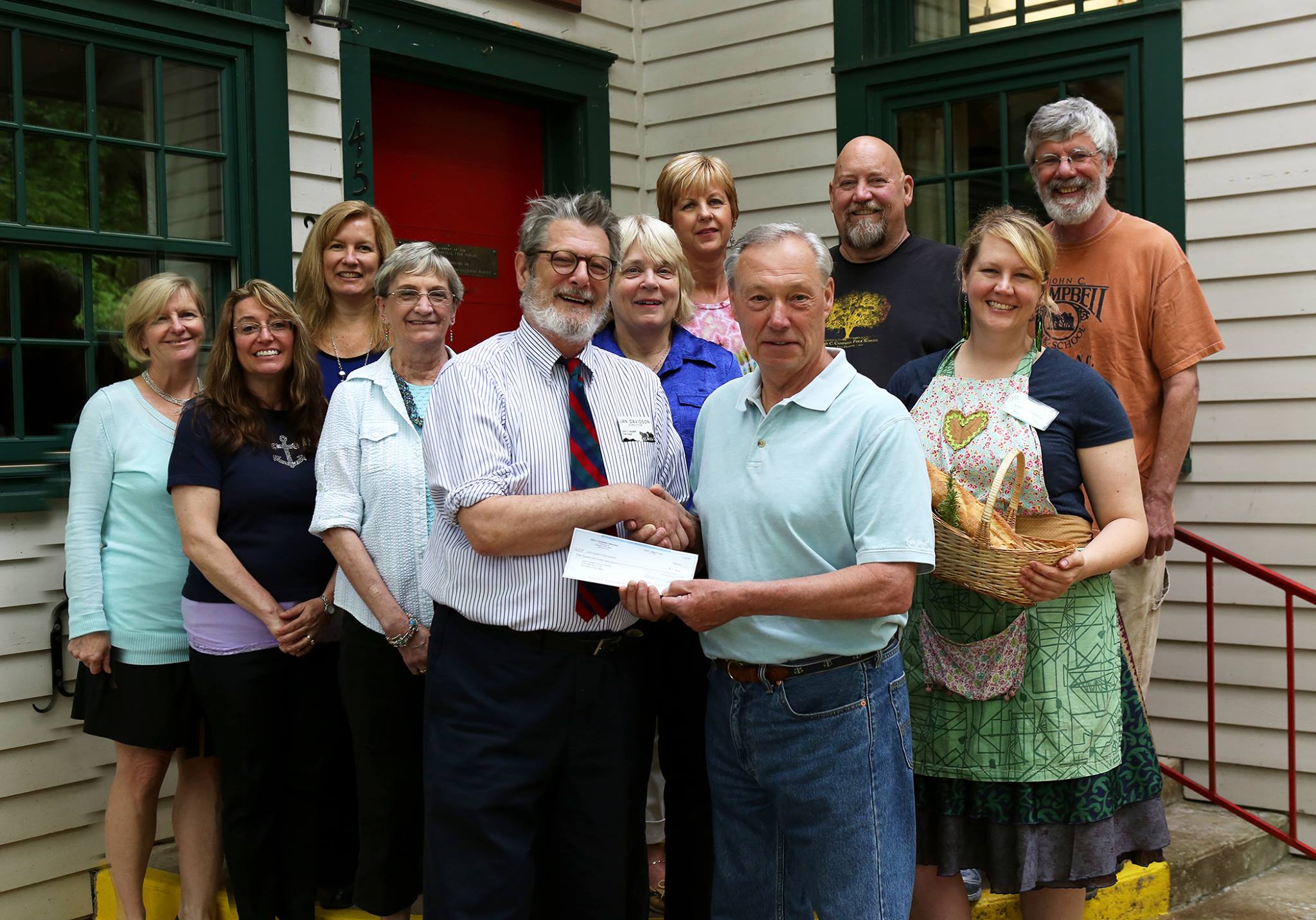 On May 10, 2016, the staff of John C. Campbell Folk School and Empty Bowls volunteers presented a check for $3,188 to Fred Sickel, President of Clay County Food Bank. The Food Bank provides food for over 1200 families each month, 30% who are children. Presenting the check, Folk School Director Jan Davidson and Fred Sickel. Also pictured from left to right: Kate Delong, Ellen Sandor, Jennifer Slucher, Dianne Arnold, Marianne Hatchett, Colleen Plonsky, Mike Lalone, Cory Marie Podielski, and Harry Hearne. The Empty Bowls fundraiser for Cherokee and Clay County food banks has been hosted by the John C. Campbell Folk School for the past 10 years.