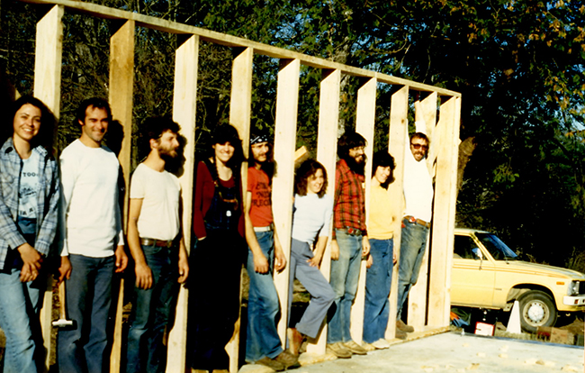Participants in the Homesteading Program stand in the wall of Little House, which they built in 1981. (L-R: Toni Meador, "Jim" Andy Ward, Nanette Buchen, Michael Thornton, Kim Box, Mike Oliphant, "Anita," Gerard Archibald.