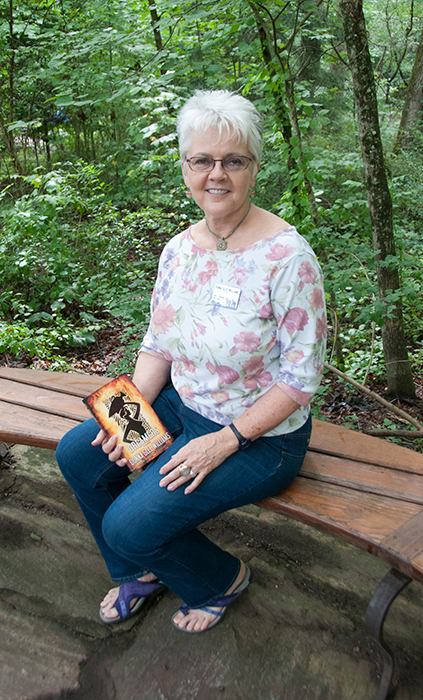 Donna Glee Williams outside of Keith House with her book, the Braided Path