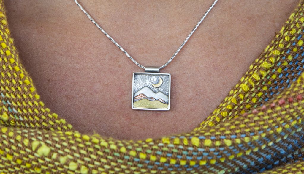 A pendant by Barbara Joiner paired with woven apparel by Deborah Bryant
