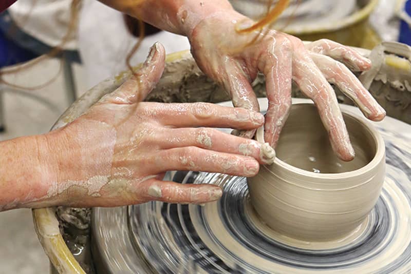 Hands on turning clay pot