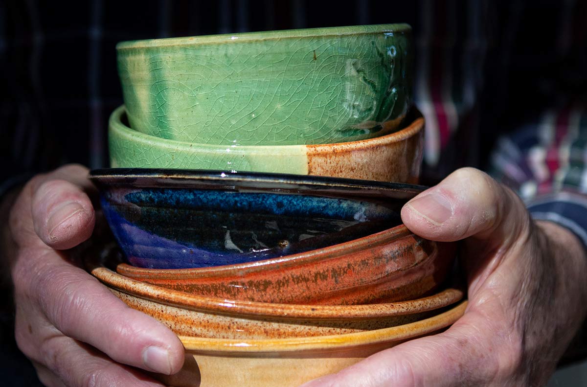 Hands holding a stack of bowls