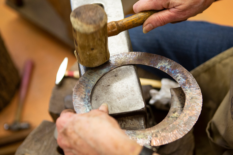 Hammering a circular metal piece