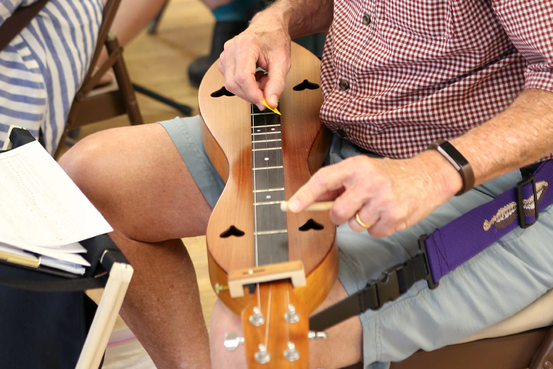 Image of man playing the Dulcimer