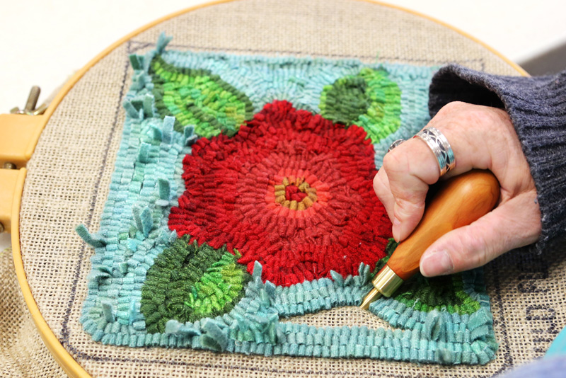 Image of a woman rug hooking