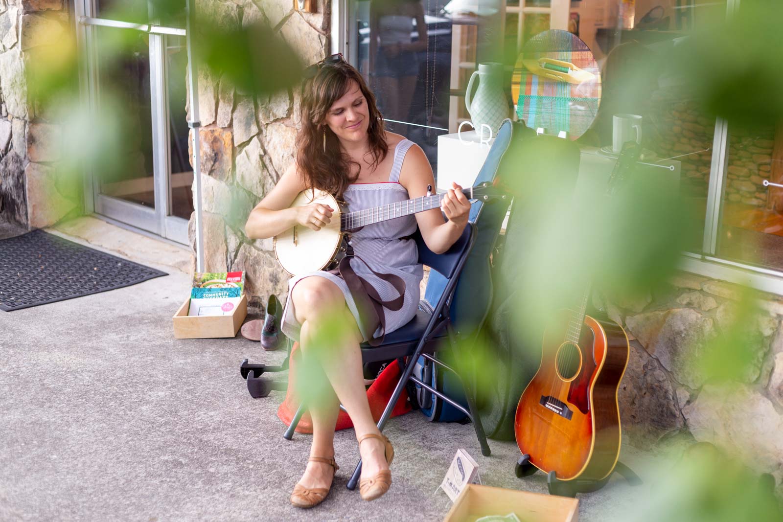 Becky Hill playing banjo outside of Olive's Porch