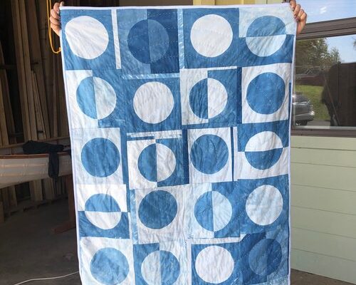 An indigo-dyed blanket with a circle design on display