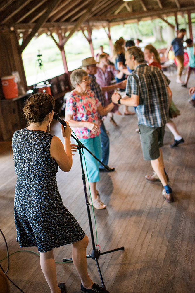 Becky Hill calls a square dance in Open House.