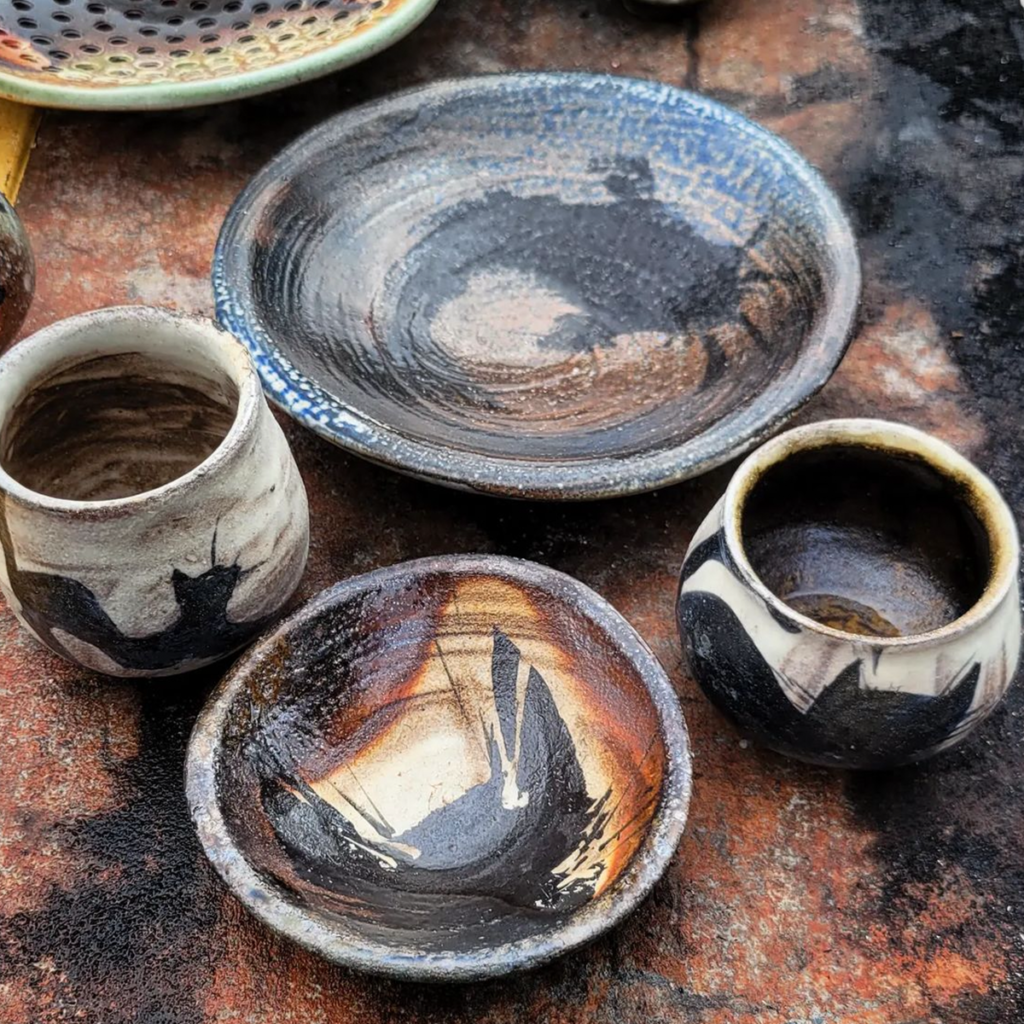 Soda fired plates and mugs with cat designs on each