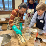 Students and instructor Allison Haigler pouring soap into a mold and creating a design.