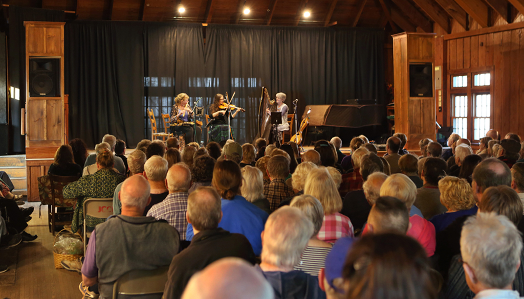Band playing for a large crowd in the Folk School's Keith House Community Room