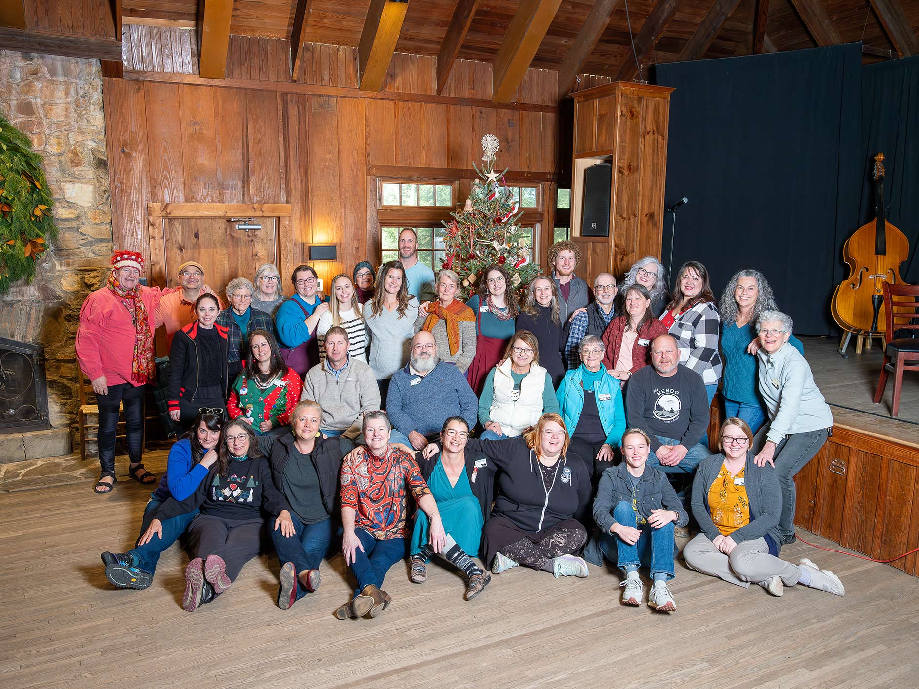 folk school staff posing in front of christmas tree in keith house community room.