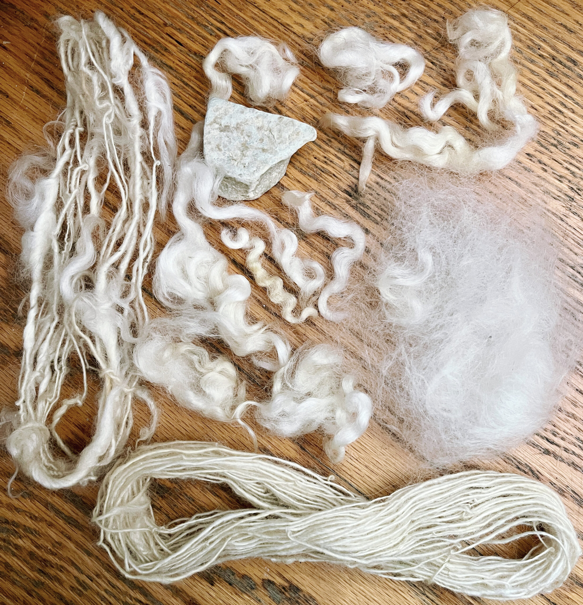 white wool locks and handspun yarn