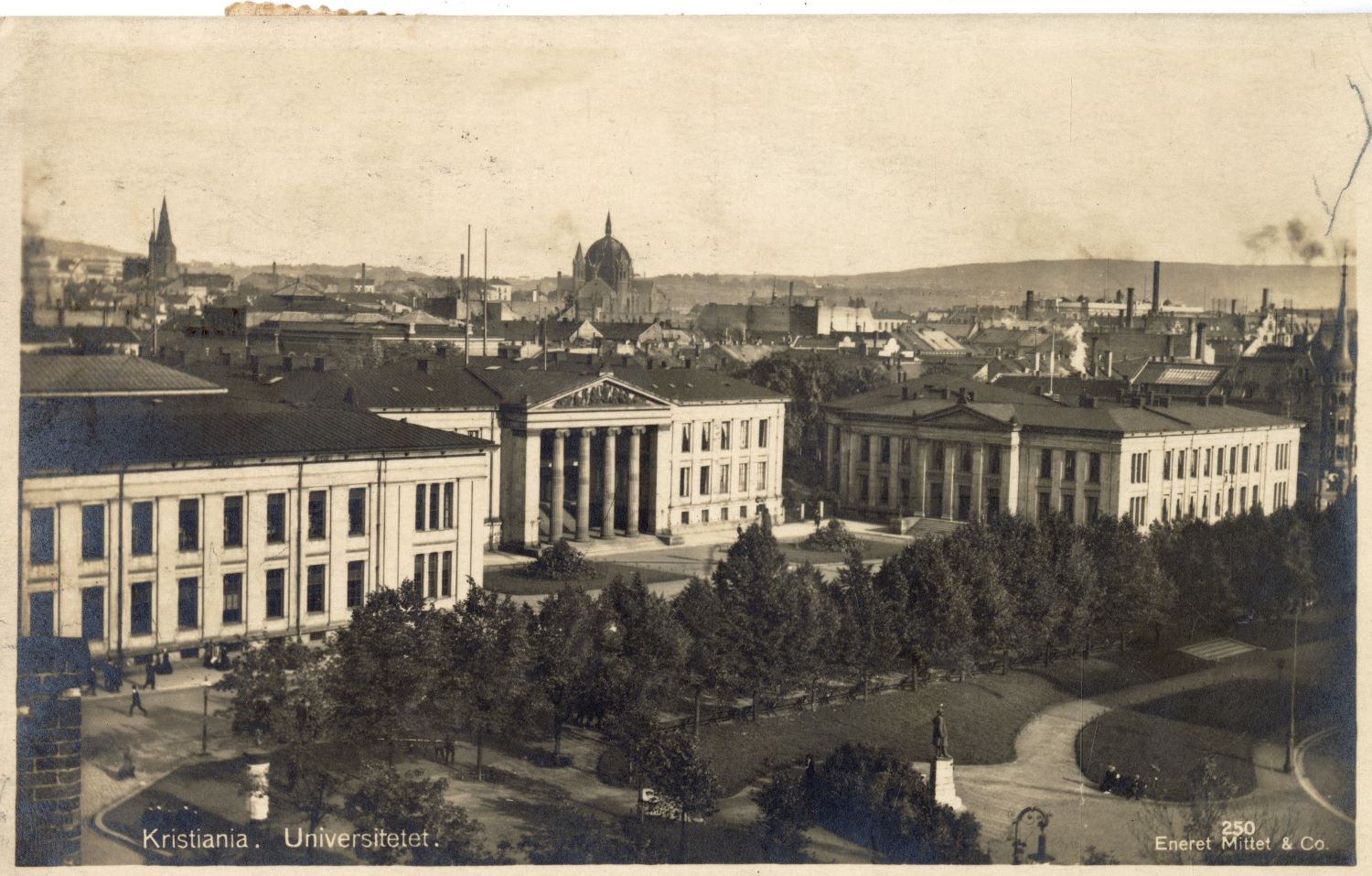 black-and-white postcard photograph of complex of two- and three-story classical-style buildings in a city