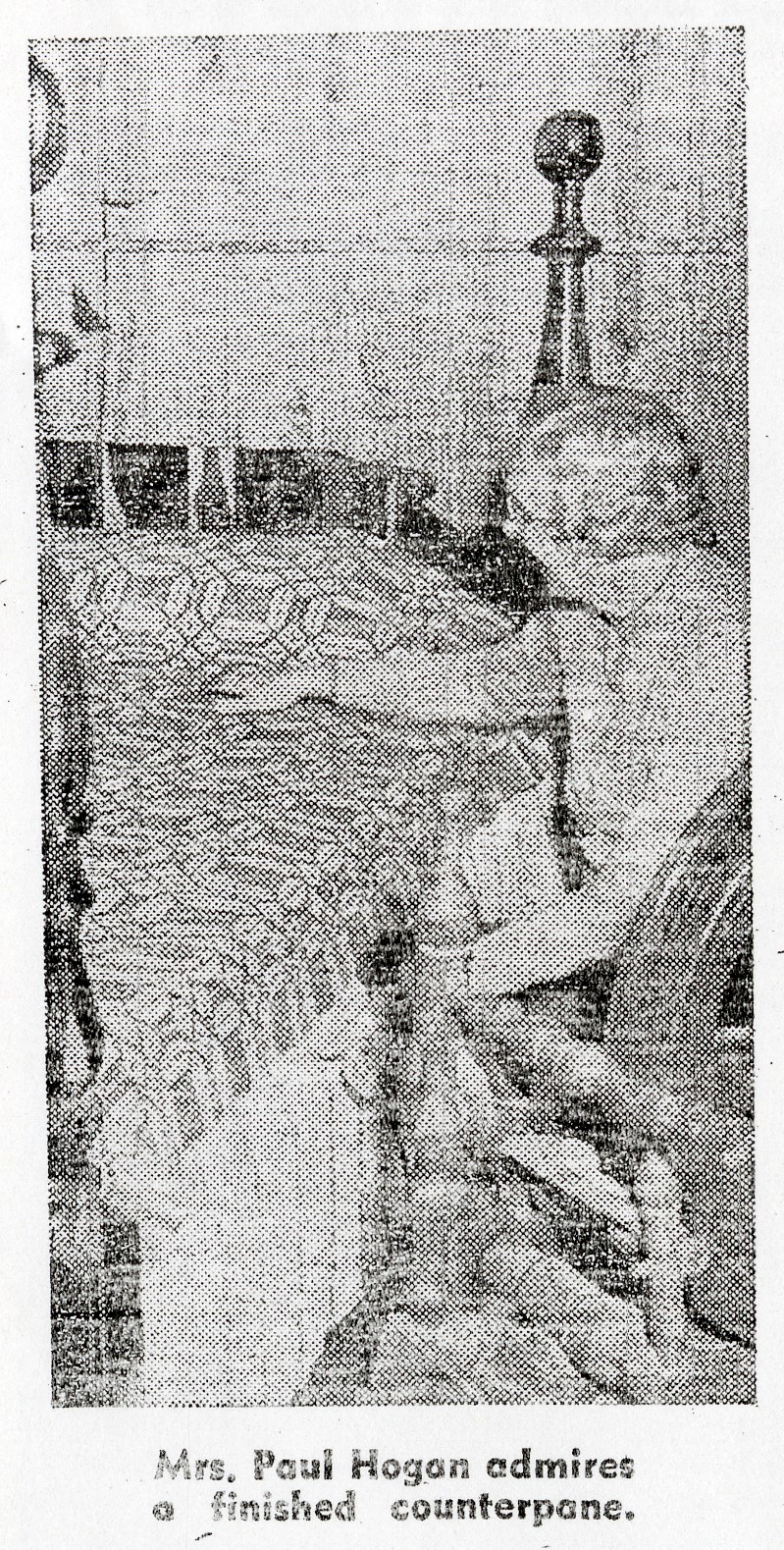 Hogan04 newspaper photo of a woman sitting by a four-poster bed covered by a coverlet, with caption "Mrs. Paul Hogan admires a finished counterpane."