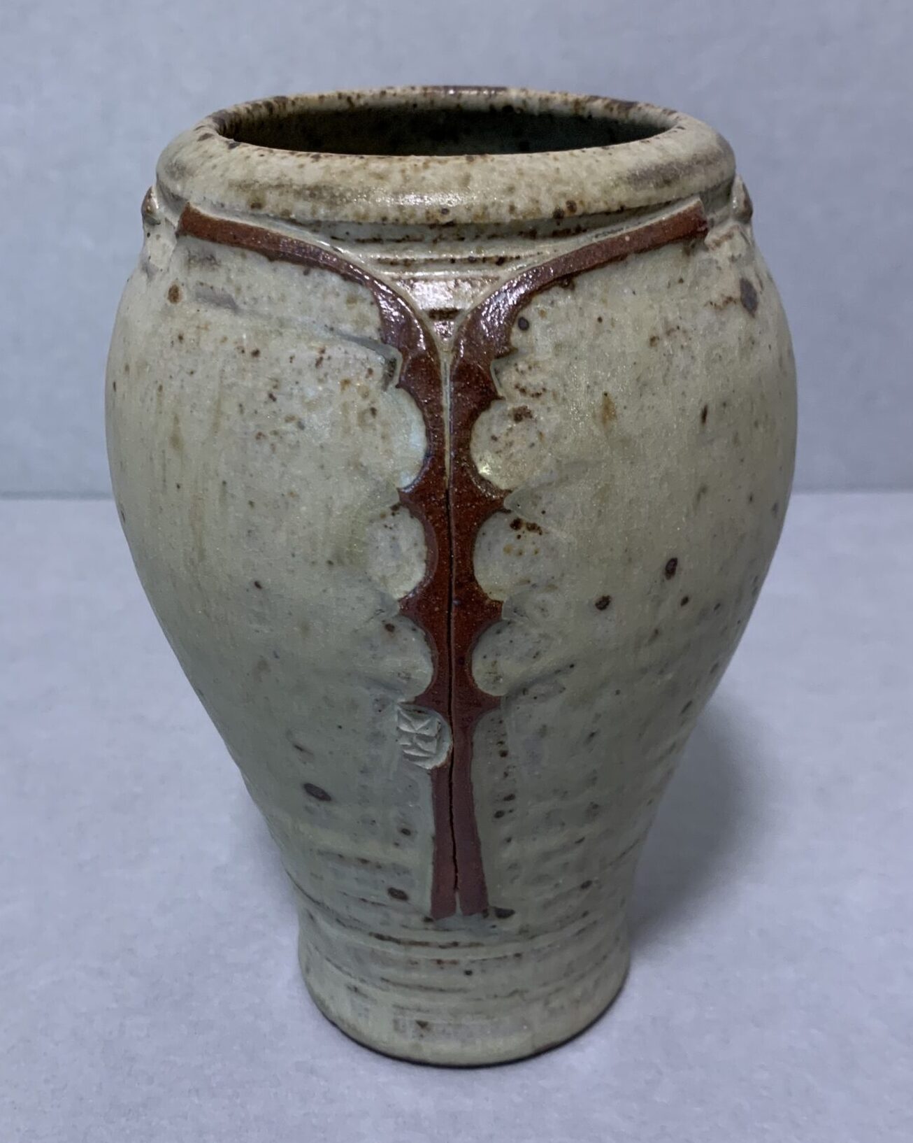 round, gray glazed vase with red design around rim and in vertical stripe down side