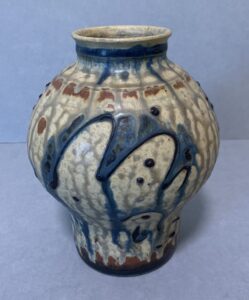 round, beige glazed vase with abstract designs in dripped blue slip