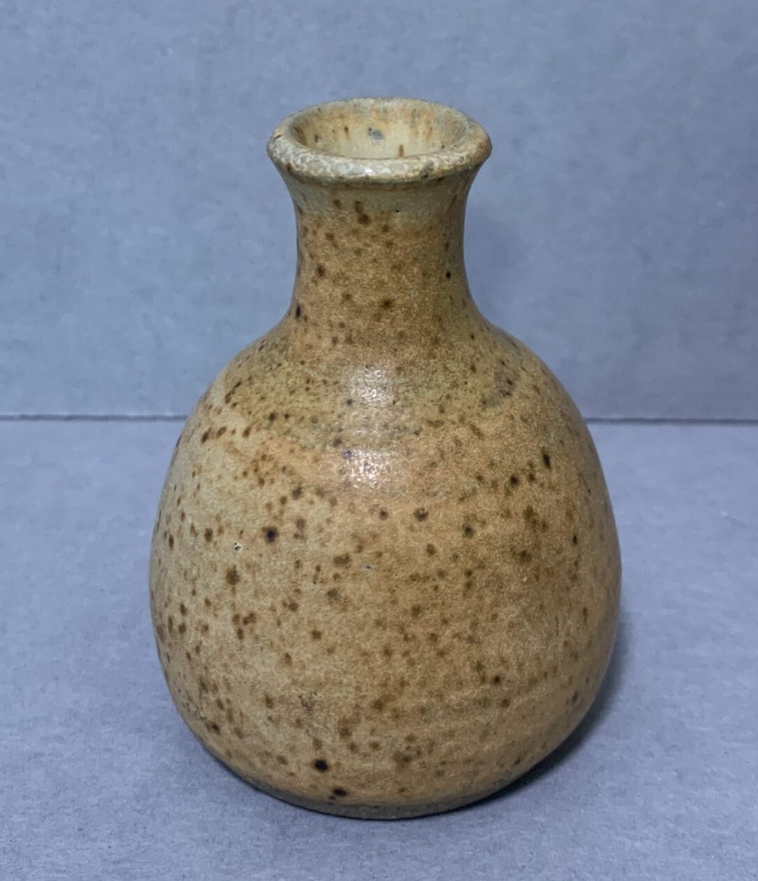 small, mottled-brown glazed ceramic vase with narrow neck