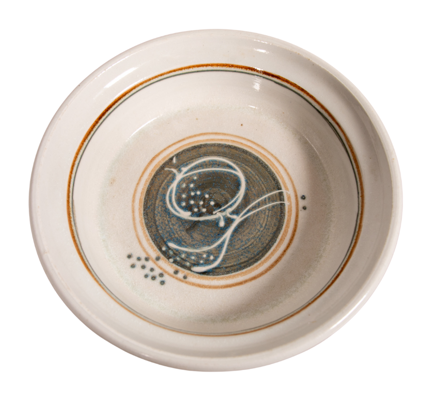 white glazed ceramic bowl with abstract circular and two-line design in brown, white, and orange