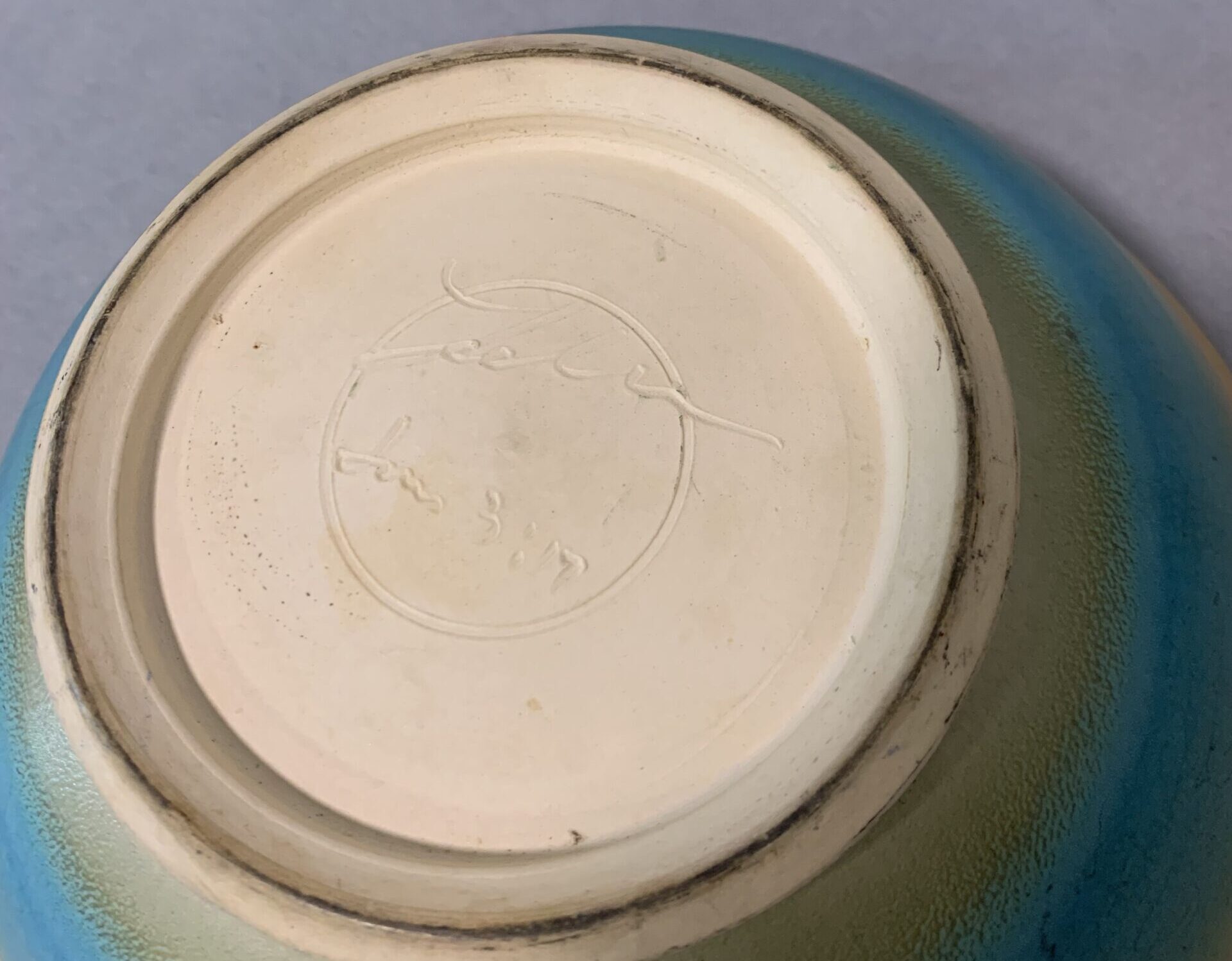 underside of a ceramic bowl with illegible potter's signature