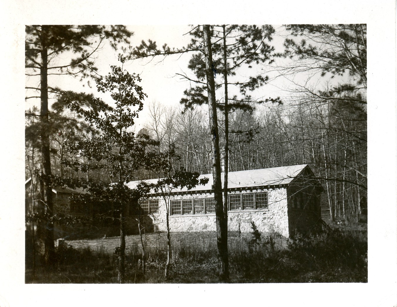 2025-45-037 black-and-white photo of one-story stone building with gable roof and many windows