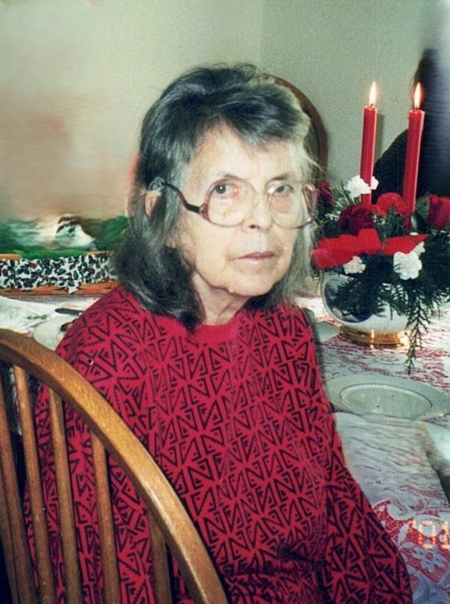 Margaret Hollingsworth 2001 elderly woman with shoulder-length gray hair, wearing glasses and red patterned sweater sitting at a holiday table